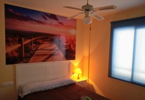 1 dormitorio con una pintura de un muelle en la pared en apartamento Isleta del Moro, Cabo de Gata en La Isleta del Moro