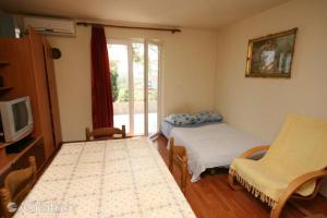 a room with two beds and a tv and a window at Apartments Zoran in Povljana