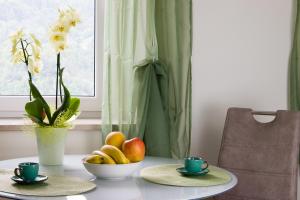 a table with a bowl of fruit and two cups at Residence Belvedere in Barcis