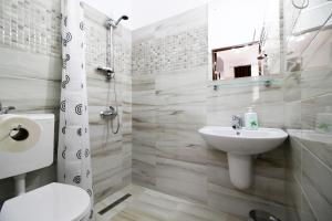 a bathroom with a sink and a toilet and a mirror at Anne's House in Sibiu