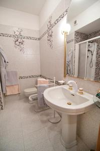 a white bathroom with a sink and a toilet at Hotel Ristorante Al Sorriso in Soriso