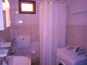 a bathroom with a white toilet and a sink at Villa Frias in Asprogerakata +47 photos