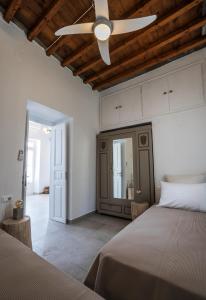 a bedroom with two beds and a ceiling fan at Komis Mansion Exambela in Exámbela