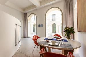 ein Esszimmer mit einem Tisch und roten Stühlen in der Unterkunft PALAZZO BECCAGUTTI CAVRIANI - Gallery Suite e Frescoes Suite in Mantua
