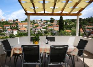 - une table sur un balcon avec vue sur la ville dans l'établissement Apartments Neda - perfect location & free parking, à Splitska