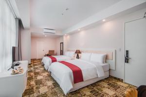 a hotel room with two beds and a window at Nobility Grand Hotel in Lima