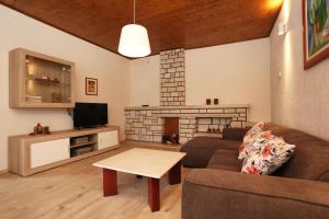 a living room with a couch and a tv and a table at House Pauline in Labin