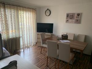 Un comedor con mesa y sillas y un televisor. en Nexis Apartment 10, en Radstadt