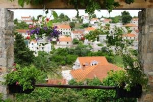 - une vue sur la ville depuis une fenêtre fleurie dans l'établissement Apartments Neda - perfect location & free parking, à Splitska