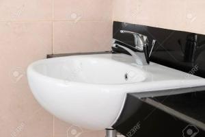 a bathroom sink with a faucet on a wall at Rose Palace Hotel, Garden Town in Lahore