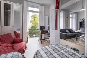 a bedroom with a bed and a couch and a desk at Apartamentos CASA CARRE 1893 in Santoña