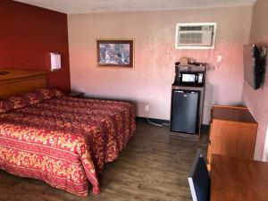 a hotel room with a bed and a microwave at Budget Inn - New Albany in New Albany