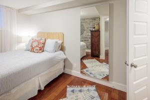 a bedroom with a bed and a mirror at The Hillside House - Downtown Kingston in Kingston