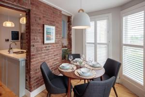 a dining room with a brick wall and a table and chairs at The Hillside House - Downtown Kingston in Kingston