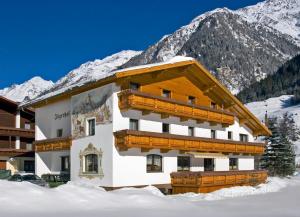 ein Gebäude im Schnee vor einem Berg in der Unterkunft Appartement Jägerhof in Sölden