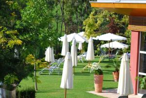 eine Gruppe weißer Schirme und Stühle auf dem Gras in der Unterkunft Hotel Stenitzer in Bad Gleichenberg
