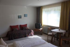 a hotel room with two beds and a television at Marias Pension in Falkenstein