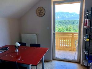a room with a red table and a sliding glass door at Apartma AS in Bled