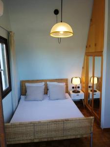 a bedroom with a large bed with white sheets and a lamp at Seagull Villa Chalkidiki in Pefkohori