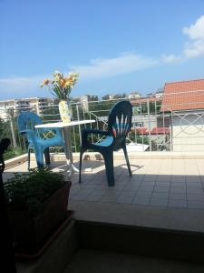 two chairs and a table with a vase on a balcony at Hotel Mistef in Falerna