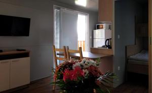 a living room with a chair and a bouquet of flowers at Mobile Homes Krko Pirovac in Pirovac
