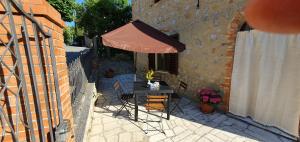 a patio with a table and an umbrella at a casa di Gabri in Montefollonico