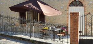 a fence with an umbrella next to a building at a casa di Gabri in Montefollonico