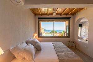 a bedroom with a large bed with a large window at Meli Suites, Thassos in Skala Potamias