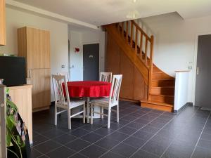 a dining room with a red table and chairs at La Raimbaudière in Guigneville