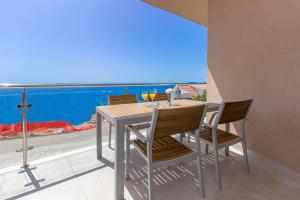 a table and chairs with a view of the ocean at Villa Ilenia in Murter +84 photos