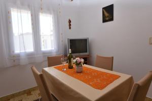 ein Esszimmer mit einem Tisch und einer Flasche Wein in der Unterkunft Apartments Visnja in Primošten