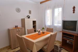 a dining room with a table and a television at Apartments Visnja in Primošten