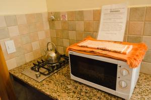an orange blanket on top of a microwave on a counter at Unquehue Apartamentos Dormis in Villa La Angostura