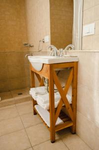 y baño con lavabo y ducha. en Unquehue Apartamentos Dormis en Villa La Angostura