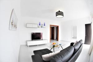 a living room with a couch and a tv at Casa Los Lajares in Tinajo