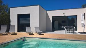 a house with a swimming pool in front of a house at Villa piscine Sud France in Verzeille