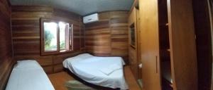 een kleine kamer met 2 bedden en een raam bij Chale Verde in Gramado