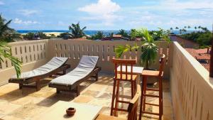 a balcony with chairs and a table and the ocean at Villa Guarani Jeri in Jericoacoara