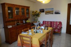 a dining room with a table with a yellow table cloth at B&B Casabella in Riposto