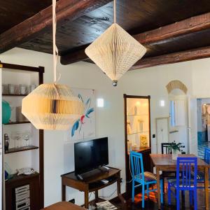 una sala da pranzo con tavolo e 2 lampadari a braccio di Luxuria 3 a Iglesias