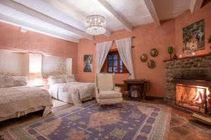 a bedroom with a fireplace and a bed and a chair at La Casa Azul Huasca in Huasca de Ocampo