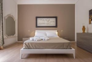 een slaapkamer met een bed met twee handdoeken erop bij Art House in Siracusa