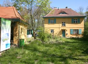 a yellow house with a sign in front of it at Radstation Menz in Menz