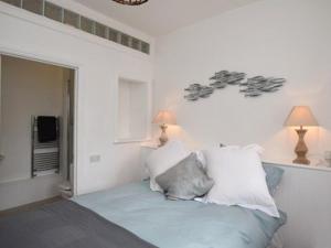 a bedroom with a bed with pillows and two lamps at Burton House Apartment in Lyme Regis