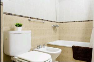 La salle de bains est pourvue de toilettes, d'un lavabo et d'une baignoire. dans l'établissement Tranquilo, comodo y cerca de todo, à Córdoba