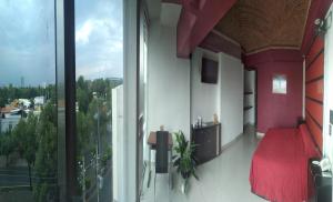 a bedroom with a red bed and a large window at Hotel Quinta Tlalpan in Mexico City