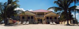 a house on the beach with chairs and palm trees at Inn at White Horse Guest House in Hopkins
