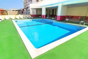 a large swimming pool with chairs next to a building at Lovely oceanview beach house in Portimão