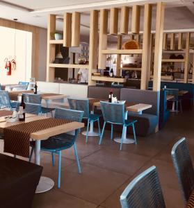 a restaurant with wooden tables and blue chairs at apartamento vista mar in Aquiraz