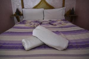 A bed or beds in a room at Riad Jenan Adam